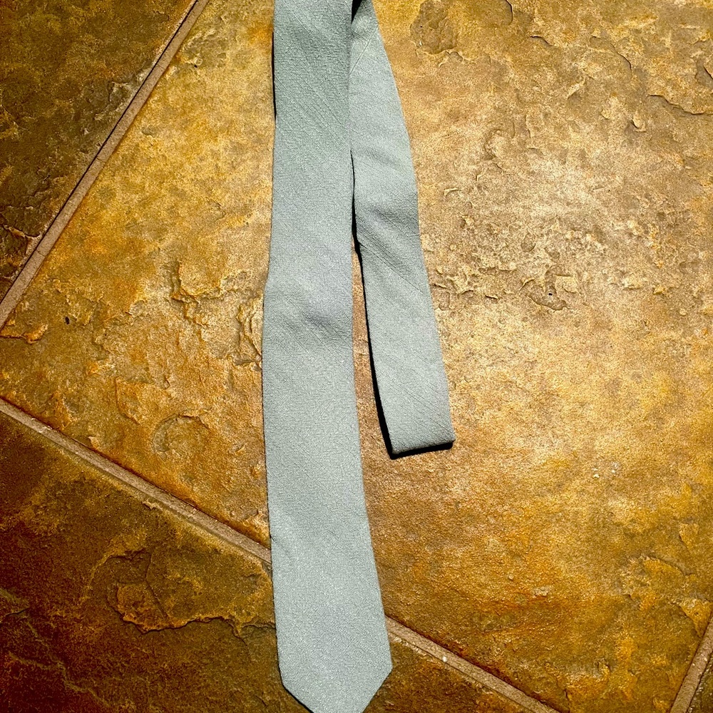 New tie, slight pattern on the front. Greenish grey color.